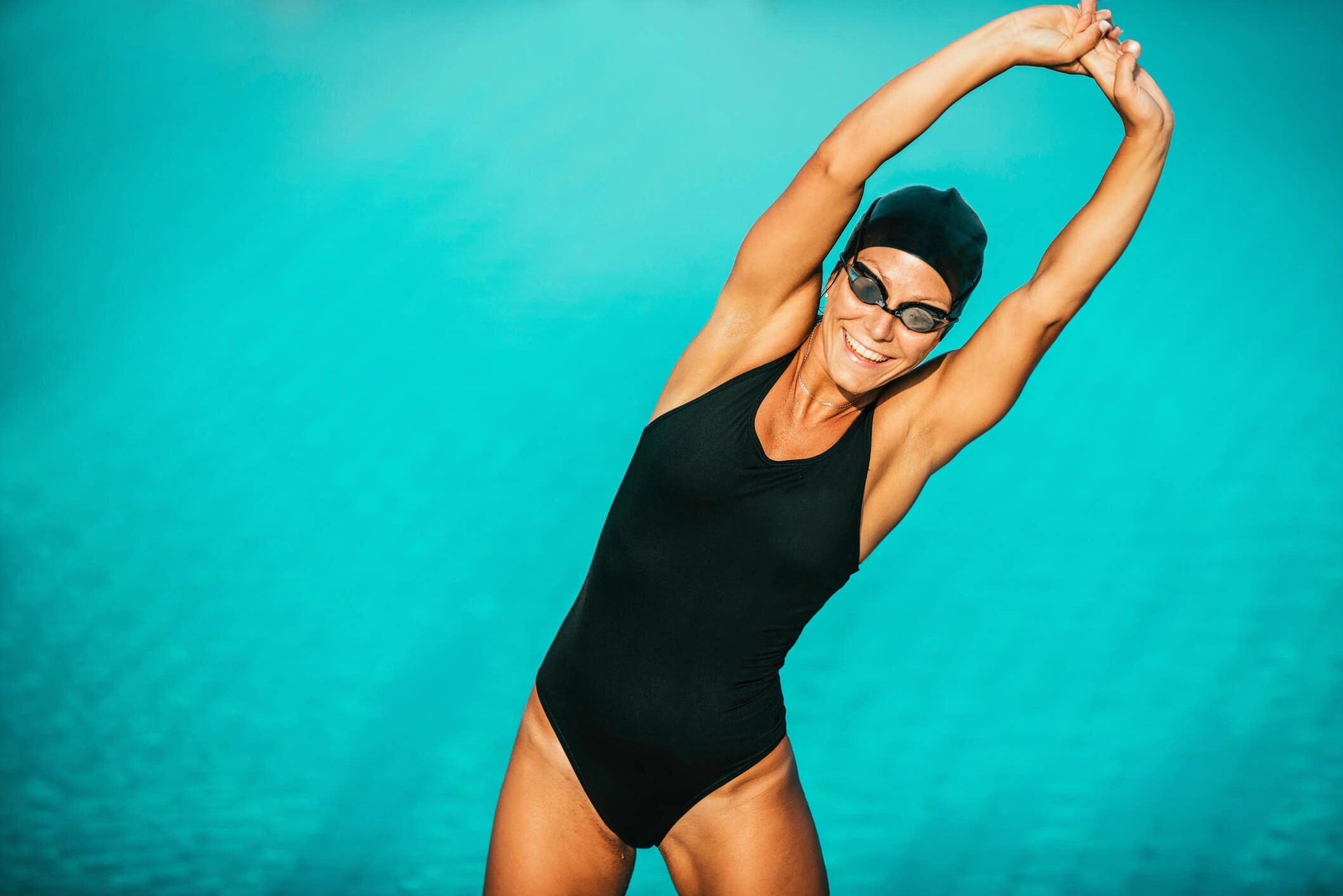 apoolco_frau_schwimmtraining_taucherbrille_pool Frau vor Pool dehnt sich