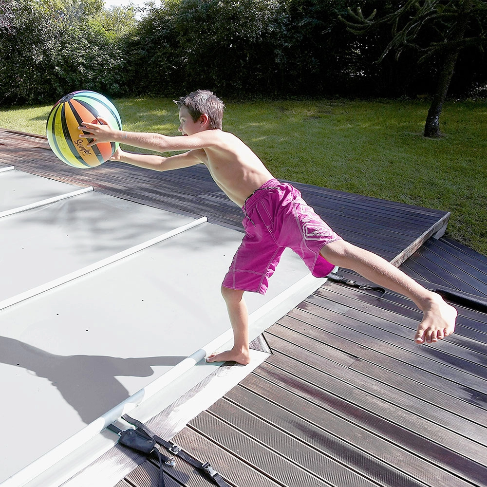 junge-mit-ball-auf-stangenabdeckung-fuer-pool Stangenabdeckung P-580 Rechteck 1100 x 350 cm inkl. Kurbel
